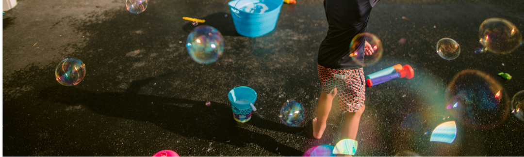 Child playing outdoors with soap bubbles