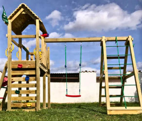 Parque infantil de madera con columpio, red de escalada, escalera y tobogán en el jardín
